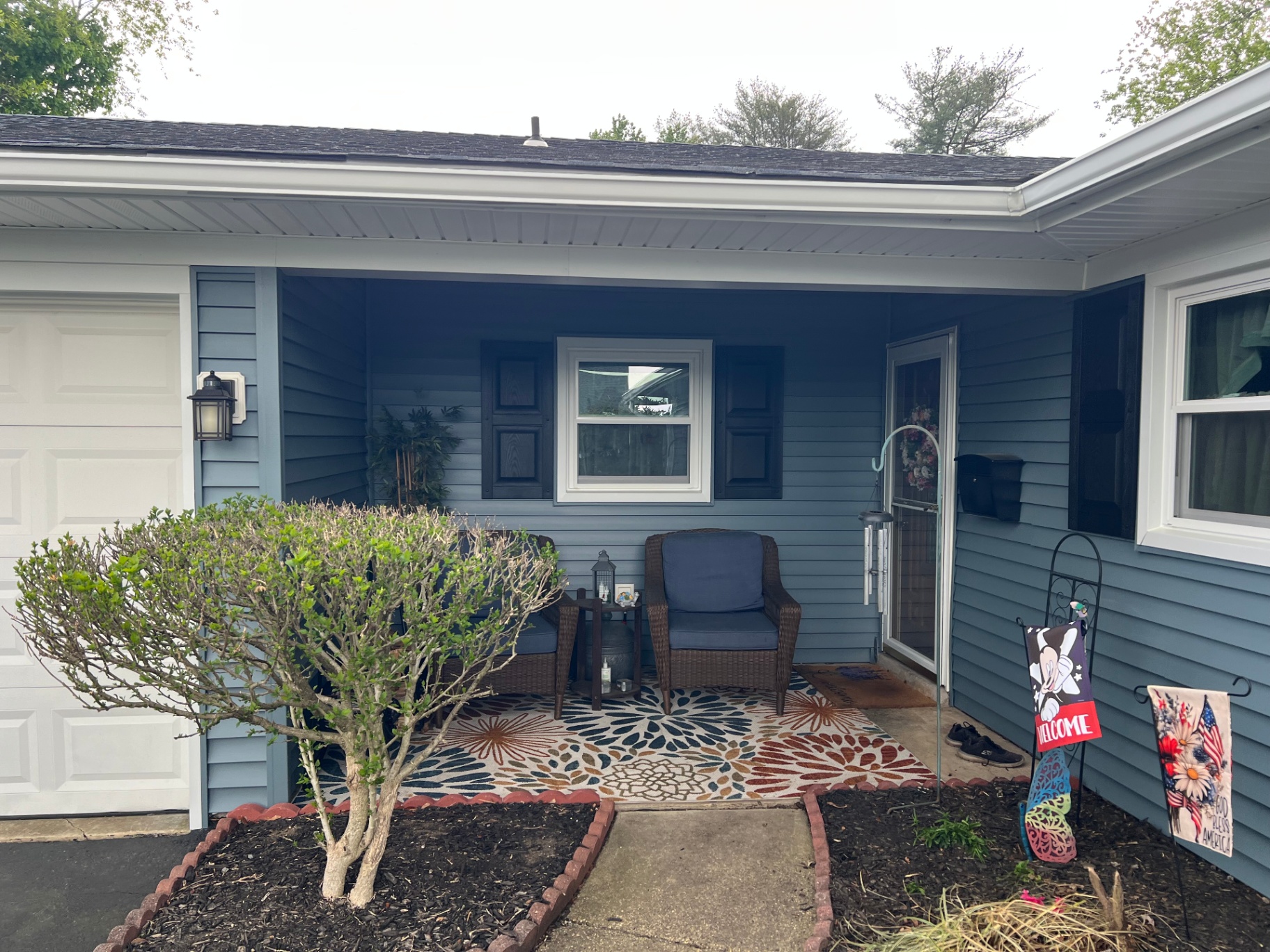 Covered porch with blue vinyl siding, soffit and white trim
