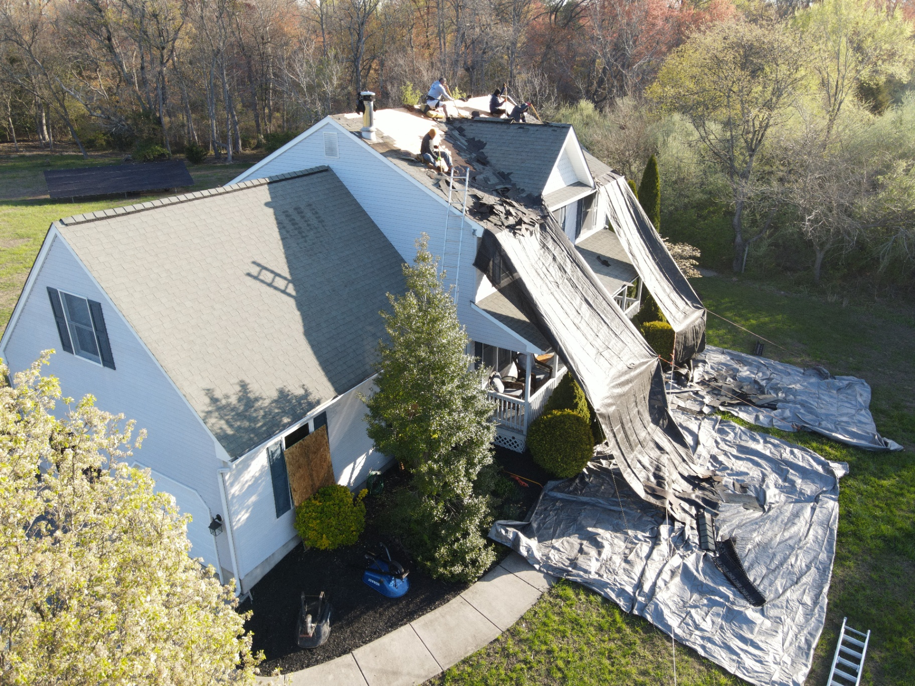 Roof replacement in progress on a steep residential roof