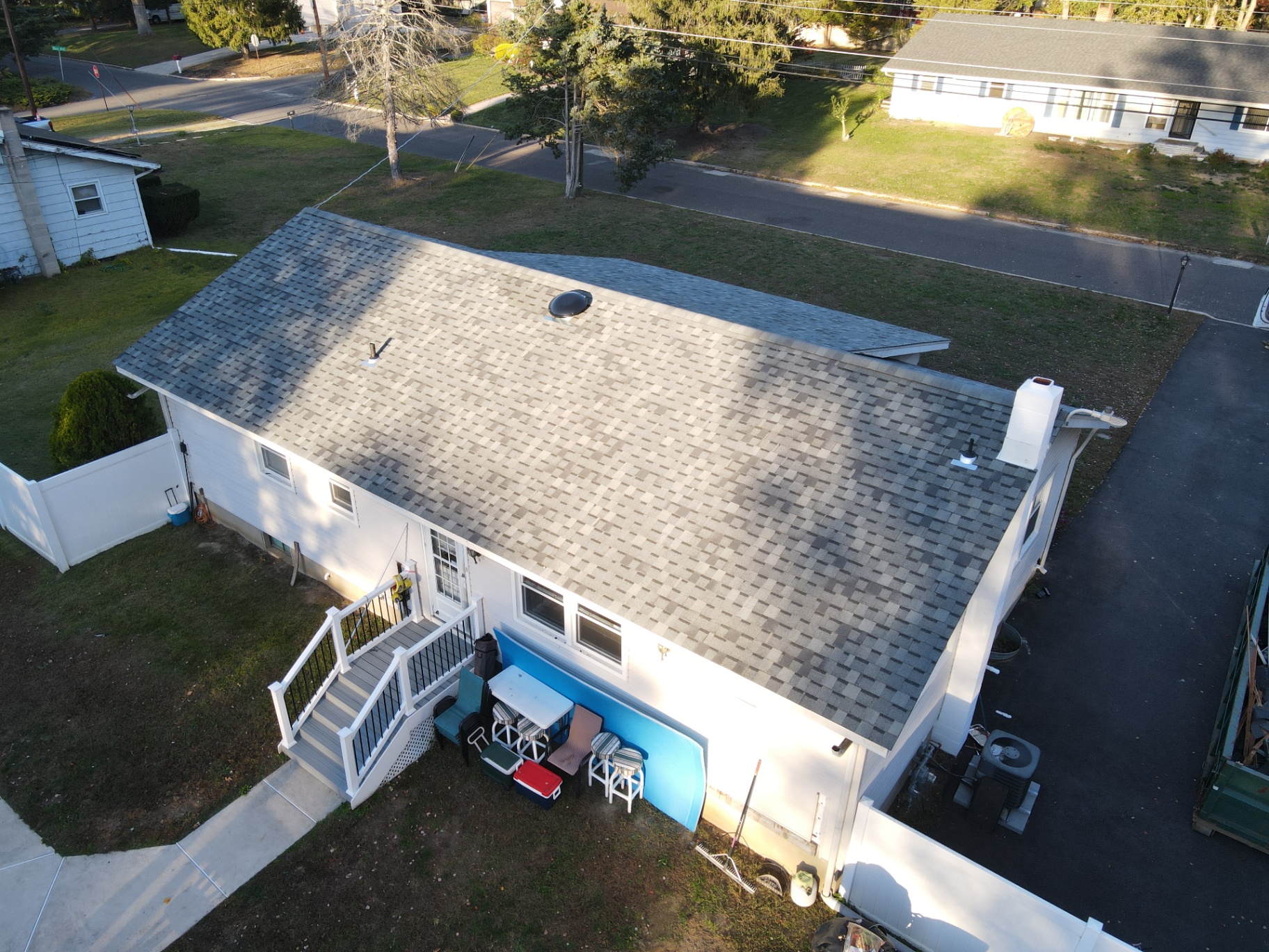 Completed light-gray shingle roof on a compact residential home
