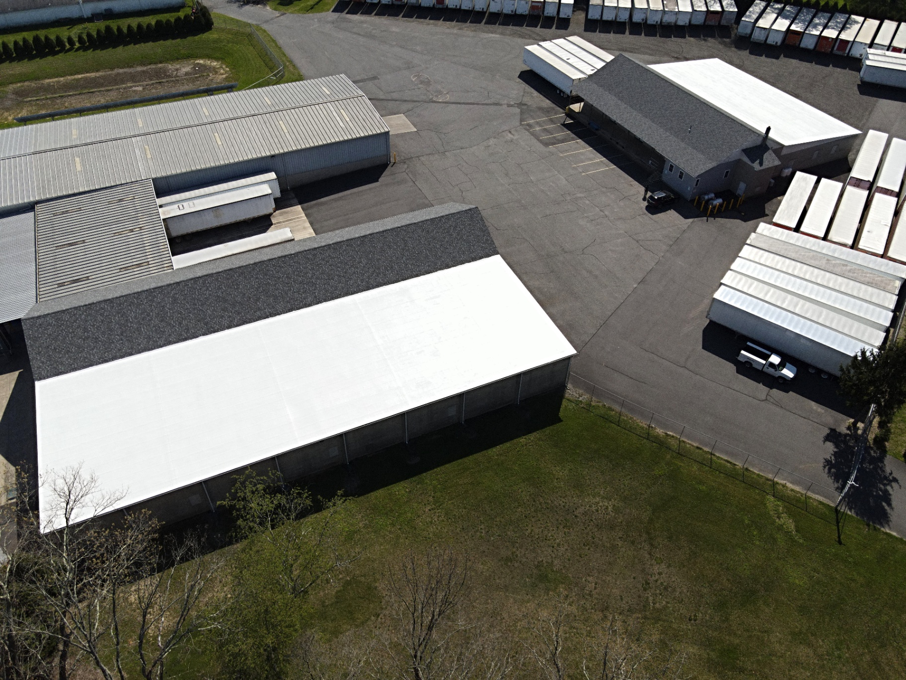Aerial view of completed shingle and white membrane roofs on commercial storage and warehouse buildings