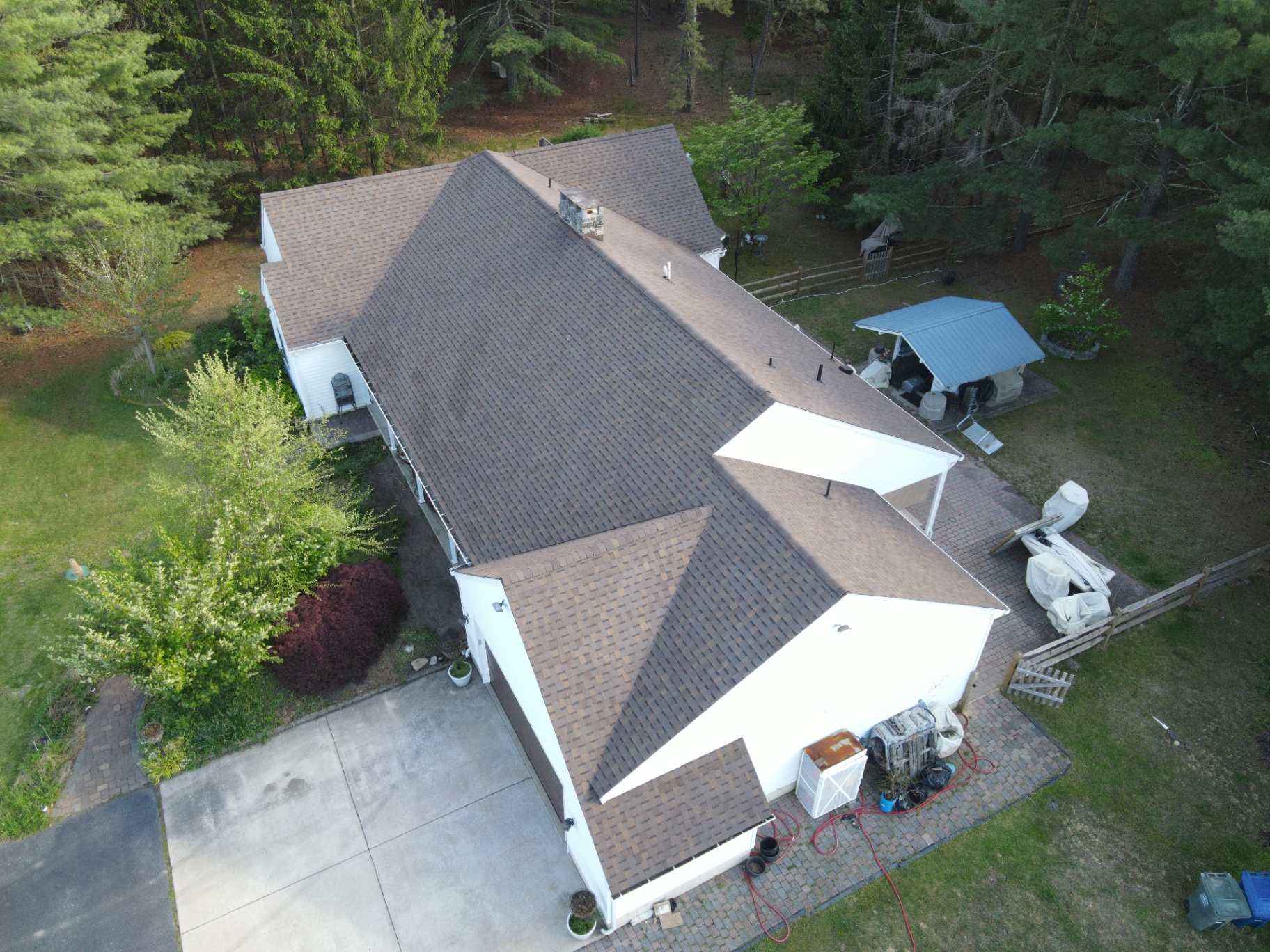 Completed brown shingle roof on a large home with complex roofline