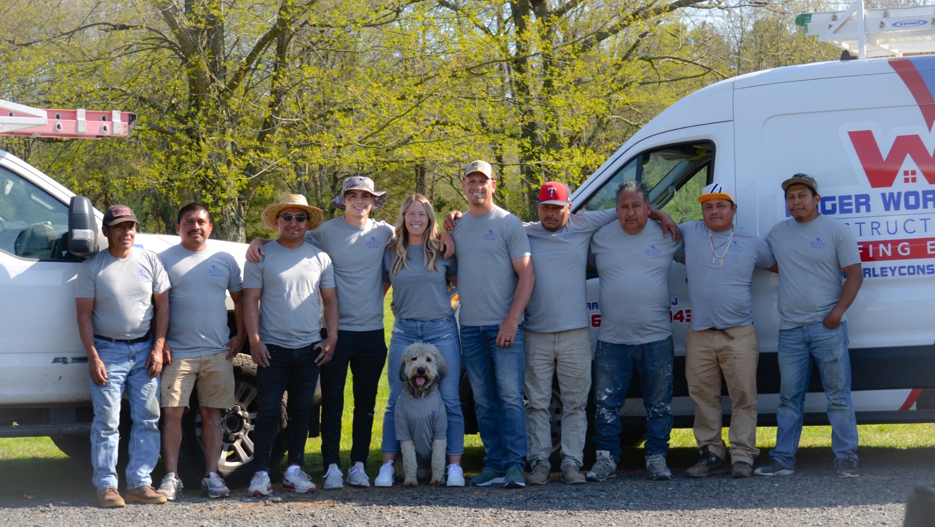 The Roger Worley Jr. Construction crew standing together in front of their work vehicles