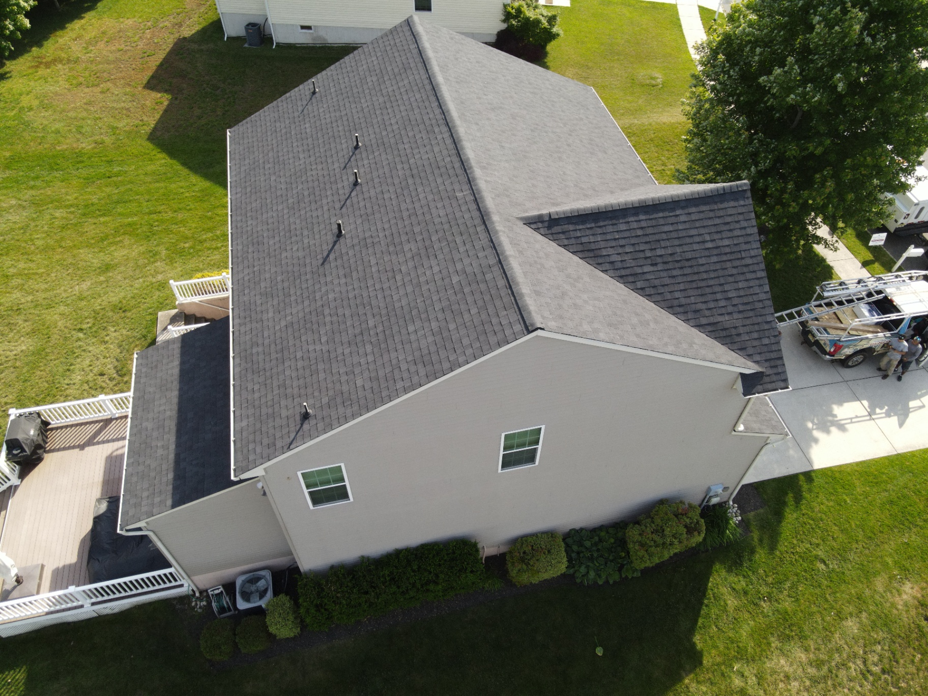 Aerial view of completed gray shingle roof on a large two-story home
