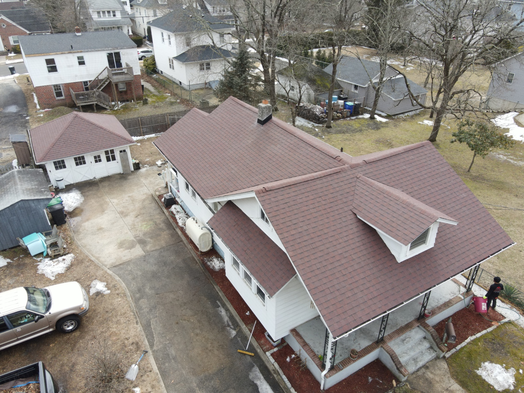 Completed brown shingle roof on a detached home and garage