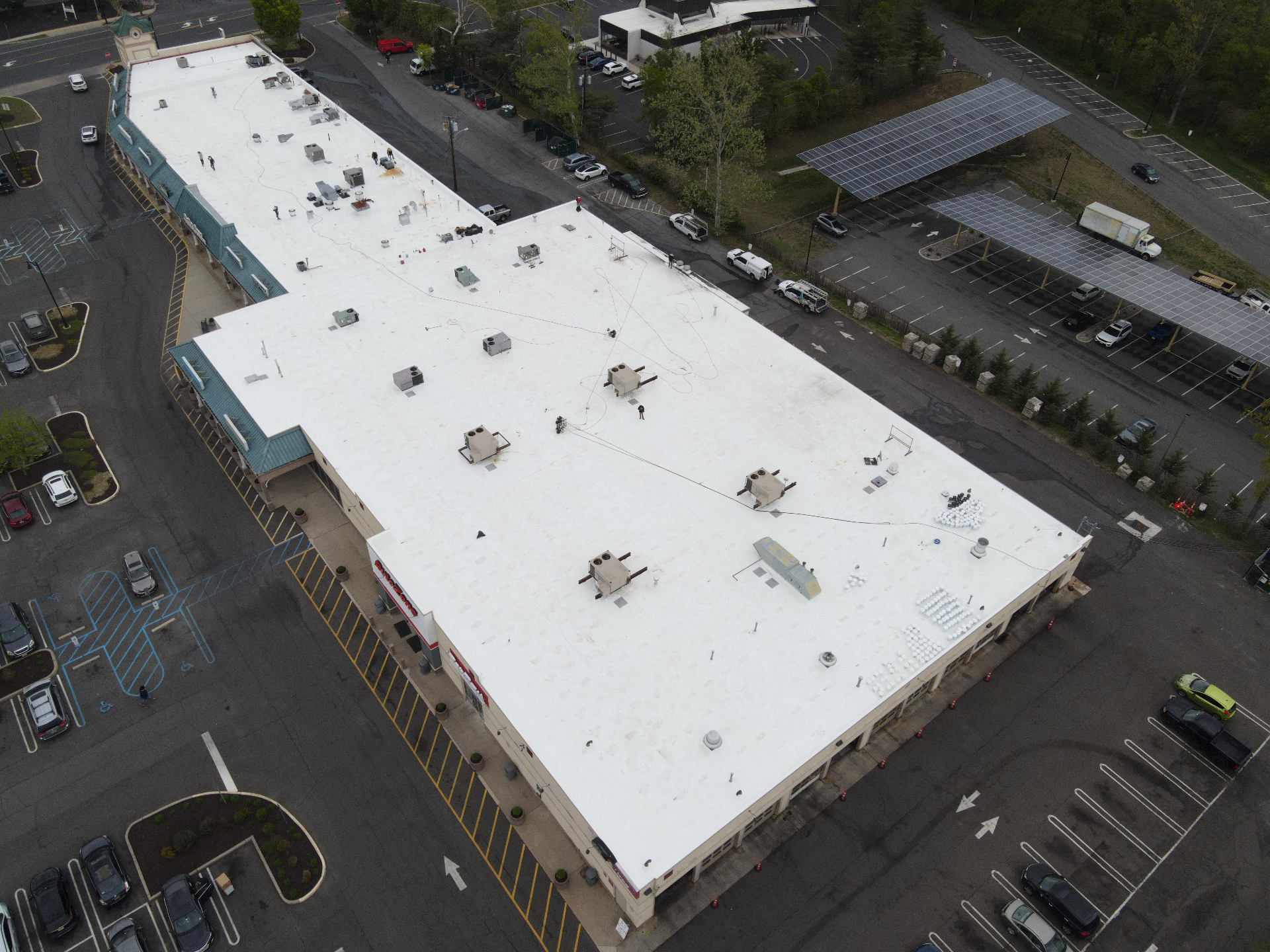Large commercial shopping center roof completed in white membrane roofing