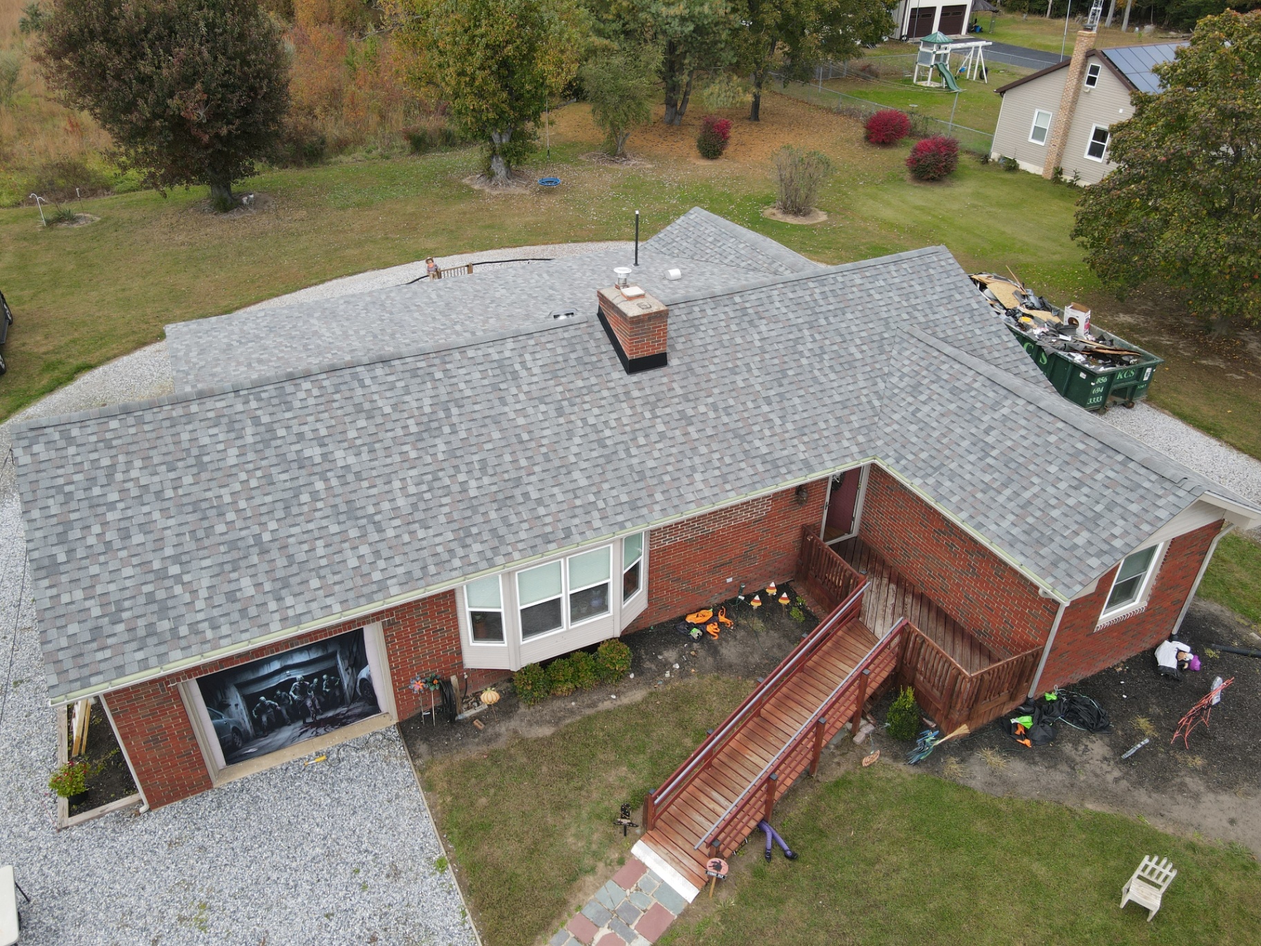 Completed gray shingle roof on a brick ranch home